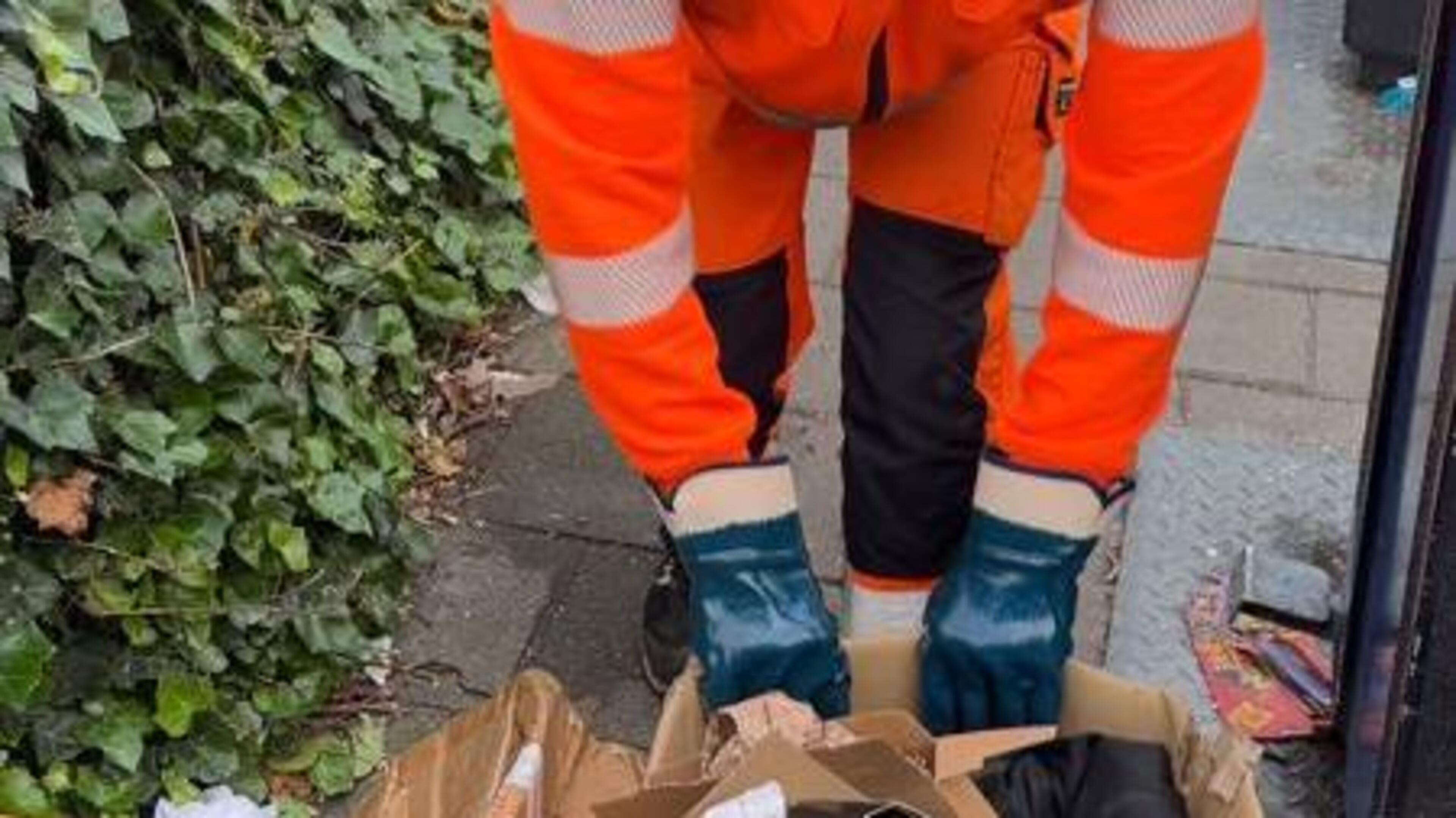 Mickey ruimt het vuilnis op dat naast de containers belandt